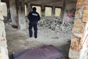 Na zdjęciu widoczny policjant, który sprawdza pustostan.