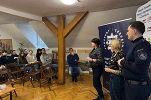 Na zdjęciu widoczny policjant wraz z przedstawicielką Miejskiego Ośrodka Pomocy Społecznej podczas spotkania z młodzieżą.