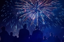 Na zdjęciu widoczne osoby przyglądające się fajerwerkom na niebie.