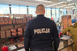 Na zdjęciu widoczny policjant i strażacy podczas kontroli punktu sprzedaży fajerwerków.