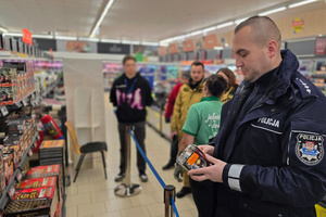 Na zdjęciu widoczny policjant i strażacy podczas kontroli punktu sprzedaży fajerwerków.