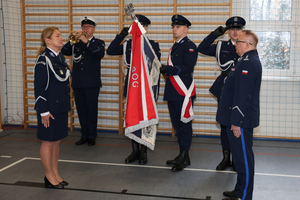 Na zdjęciu widoczny poczet sztandarowy ze sztandarem, po którego lewej stronie stoi młodszy inspektor Renata Hałabuda, a po prawej inspektor Artur Klimek.