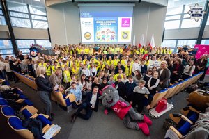 Zdjęcie grupowe, na którym widoczne są dzieci, dorośli oraz maskotki śląskiej Policji i Taurona.