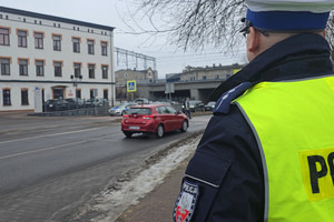 Na zdjęciu widoczny policjant obserwujący rejon przejścia dla pieszych.