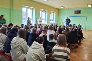 Na zdjęciu widoczny policjant, który prowadzi spotkanie z uczniami.