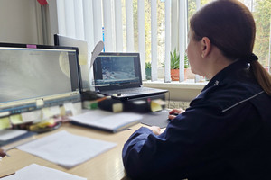 Na zdjęciu widoczna policjantka, która obserwuje wyświetlony na ekranie zapis z monitoringu miejskiego.