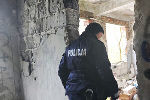 Na zdjęciu widoczny policjant, kontrolujący pustostan.