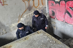 Na zdjęciu widoczni policjanci, kontrolujący pustostan.