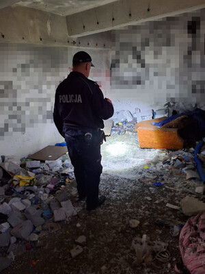 Na zdjęciu widoczny policjant, sprawdzający pustostan.