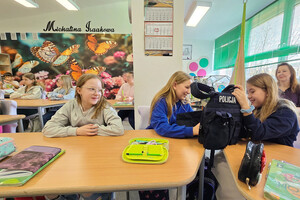Na zdjęciu widoczne uczennice, które oglądają policyjną kamizelkę.
