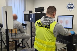 Na zdjęciu widoczny mężczyzna podczas robienia zdjęć sygnalitycznych przez technika kryminalistyki.