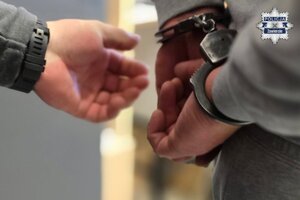 Na zdjęciu widoczne ręce mężczyzny, na które założone są kajdanki.