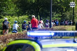 Na zdjęciu widoczny częściowo radiowóz oraz osoby, które jadą na rowerach.