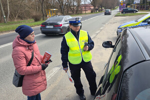 Kobieta rozmawia z kierującym. Obok niej stoi policjantka.