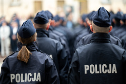 Stojący tyłem policjanci.