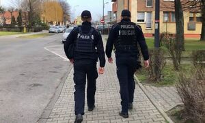 Dwóch idących chodnikiem policjantów.