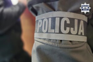 Opaska z napisem Policja, założona na ramię nieumundurowanego policjanta.