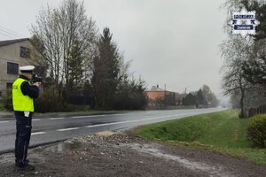 Policjant kontroluje prędkość nadjeżdżającego pojazdu.