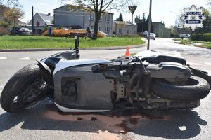 Na jezdni leży motocykl, który brał udział w zdarzeniu drogowym.