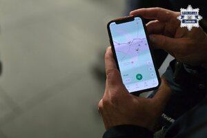 Telefon komórkowy z wyświetlonymi punktami na mapie, gdzie znajdują się AED.