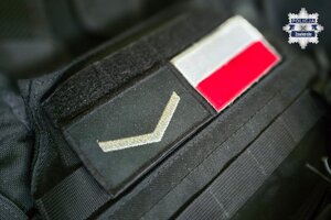 Naszywka na policyjnej kamizelce przedstawiająca symbol sierżanta oraz polską flagę.