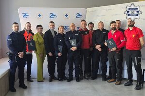 Zdjęcie grupowe, na którym widoczni są policjanci, ratownicy oraz inne osoby.