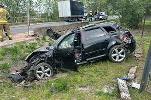 Roztrzaskany samochód osobowy, który znajduje się w przydrożnym rowie.