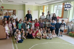 Zdjęcie grupowe policjant z dziećmi i opiekunkami.