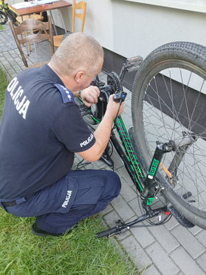 Policjant znakuje rower.