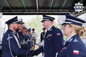 Pierwszy Zastępca Komendanta Wojewódzkiego Policji w Katowicach inspektor Radosław Kacprzak, obok którego obecna jest Komendant Powiatowy Policji w Zawierciu młodszy inspektor Renata Hałabuda, wręcza policjantowi akt mianowania.