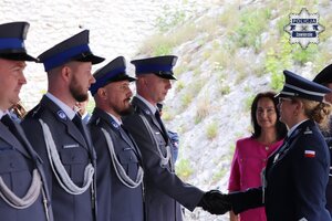 Komendant Powiatowy Policji w Zawierciu młodszy inspektor Renata Hałabuda gratuluje policjantowi. Obok widoczny Starosta zawierciański Teresa Mucha - Popiel.