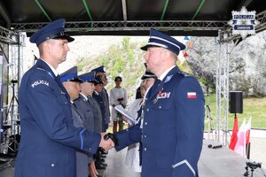 Pierwszy Zastępca Komendanta Wojewódzkiego Policji w Katowicach inspektor Radosław Kacprzak gratuluje policjantowi.