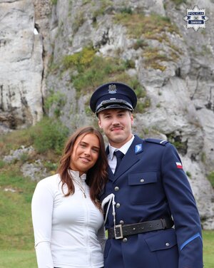 Policjant pozuje do zdjęcia z kobietą.