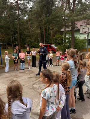 Policjant na spotkaniu z uczestnikami obozu.