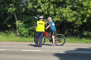 Policjant kontroluje trzeźwość rowerzysty.