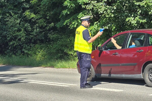 Policjant kontroluje trzeźwość kierujących samochodami.