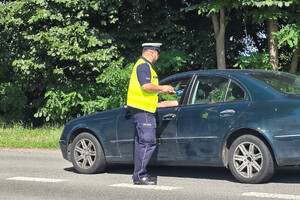 Policjant kontroluje trzeźwość kierujących samochodami.