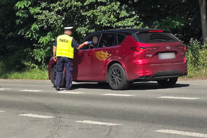 Policjant kontroluje trzeźwość kierujących samochodami.