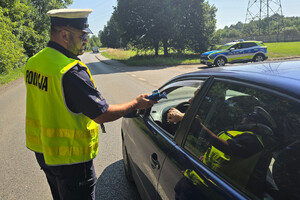 Policjant kontroluje trzeźwość kierujących samochodami.