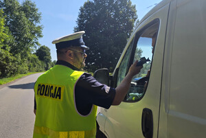 Policjant kontroluje trzeźwość kierujących samochodami.